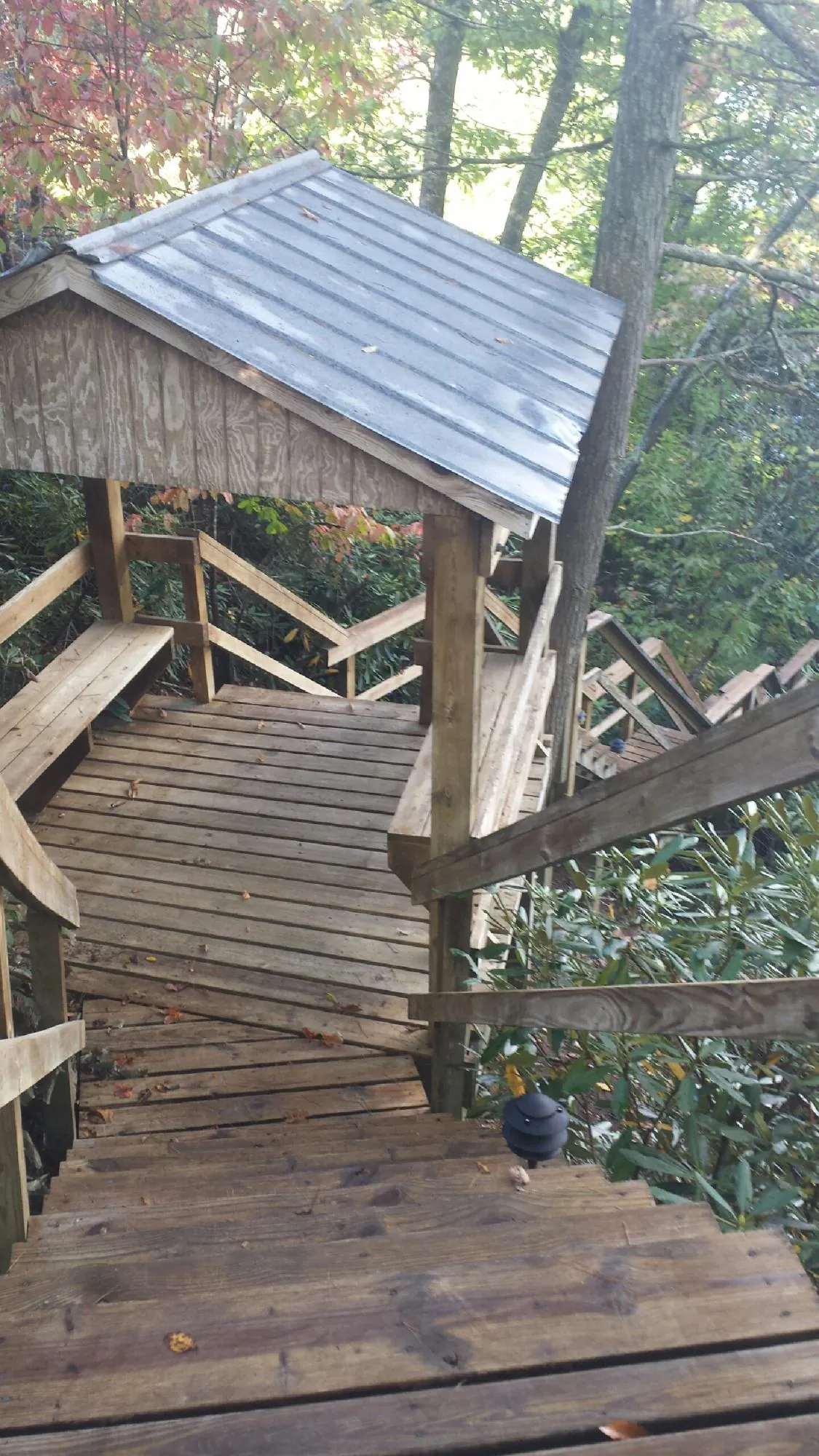 Metal roofed shelter over wooden steps on a wooded walkway — Skylight Repair & Installation work by our crew in North Waterboro