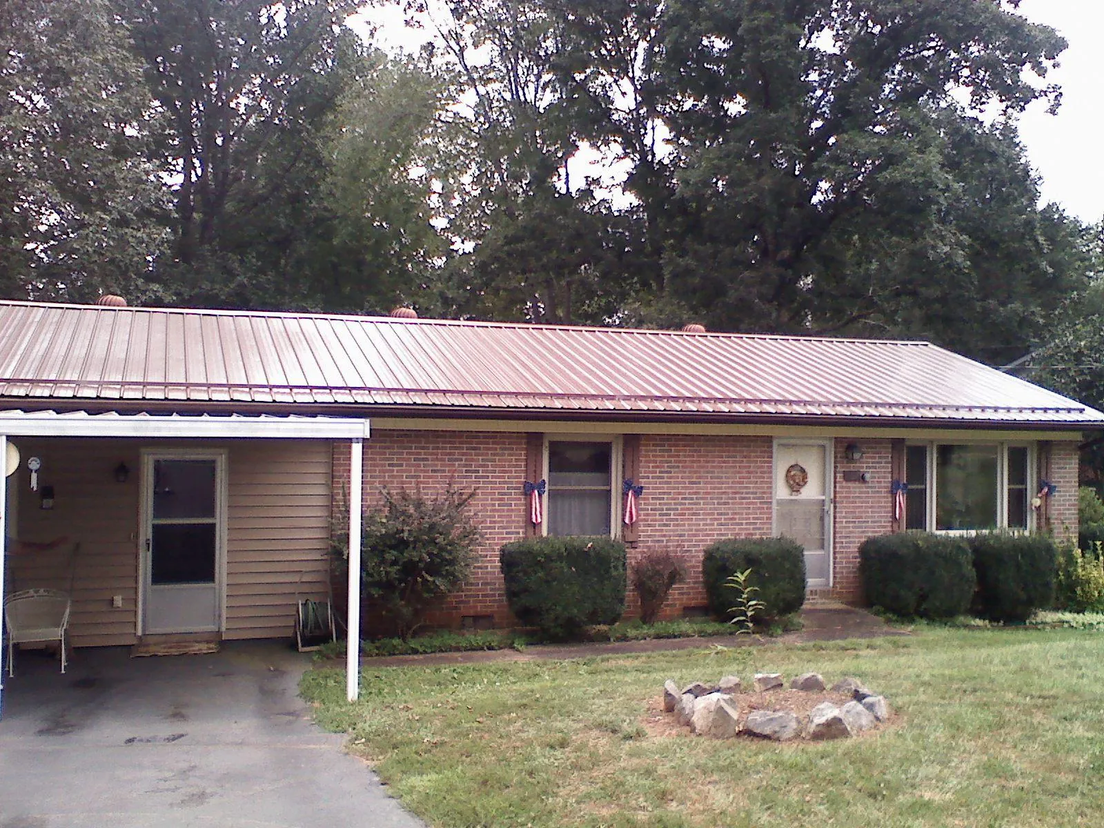 Bronze metal roof and carport on a brick ranch home — Roof Repair work by our crew in North Waterboro